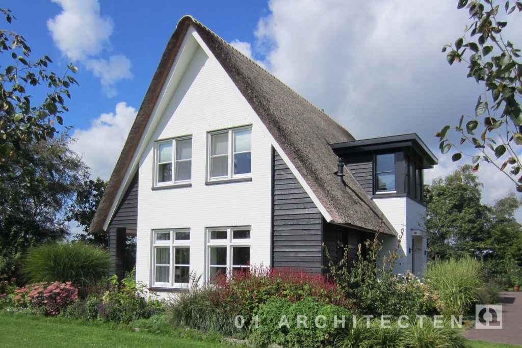 Rietgedekte woning met veranda, zwarte houten gevels en wit geschilderde gevels te Barneveld