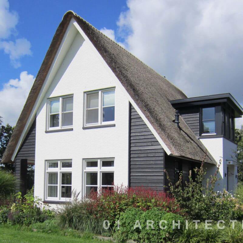 Rietgedekte woning met veranda, zwarte houten gevels en wit geschilderde gevels te Barneveld